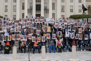 Photo of protestors at the capitol steps holding up photos
